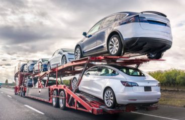 Dec 8, 2019 Bakersfield / CA / USA - Car transporter carries new Tesla vehicles along the interstate to South California, back view of the trailer